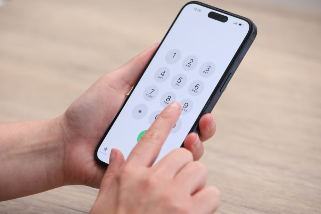 Una persona sosteniendo un teléfono con una expresión de preocupación, rodeada de información personal y financiera