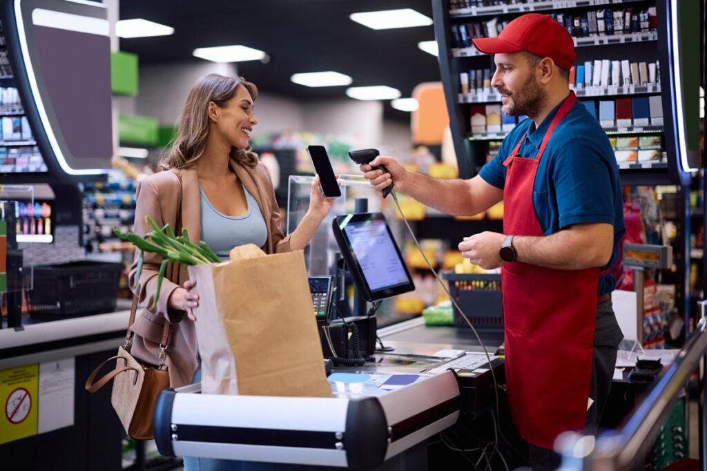 Una persona sostiene una lista de compras mientras camina por el supermercado