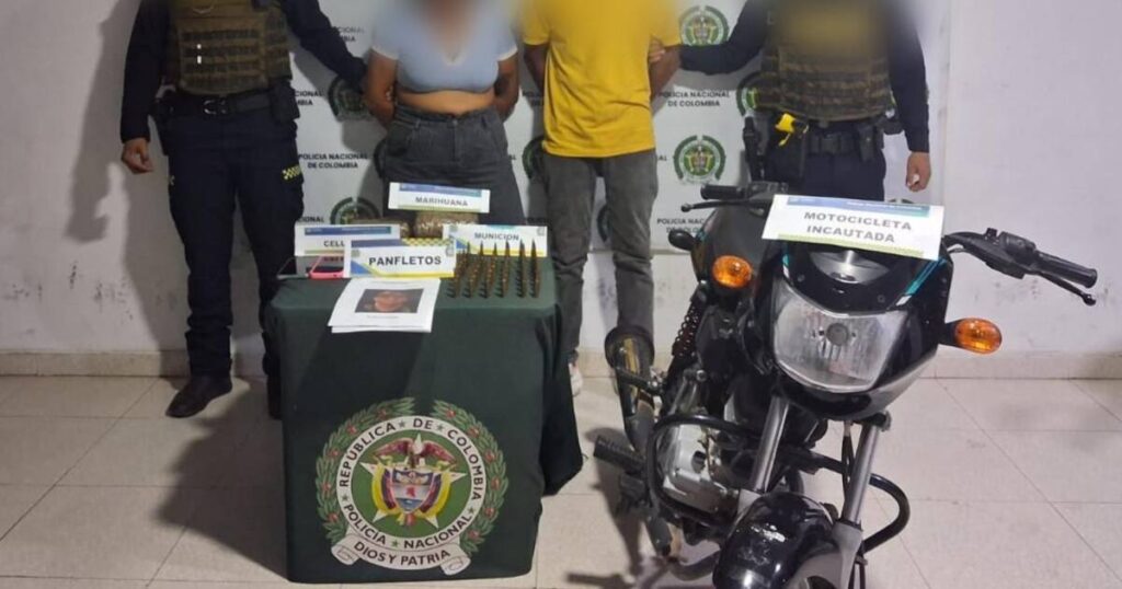 Imagen de una pareja de jóvenes siendo detenidos por la policía en un barrio de Magangué