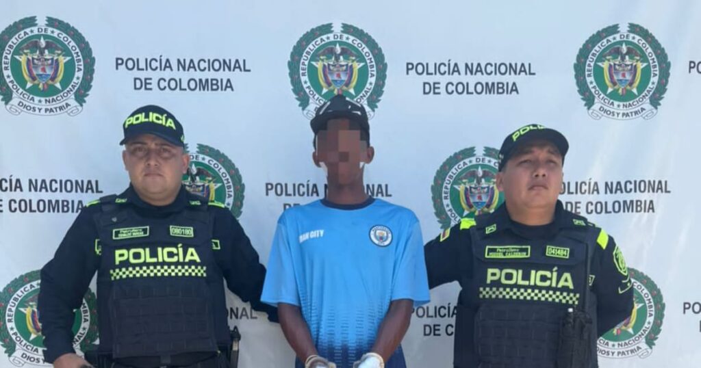 Imagen de un agente de policía llevando esposado a un hombre señalado como homicida