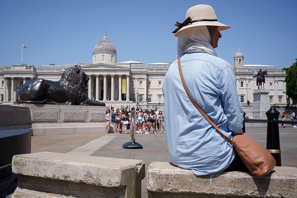 Persona bebiendo agua bajo el sol en Europa con termómetro marcando 40°C