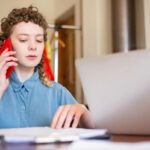 Un adolescente mirando ofertas de trabajo en una tablet con una expresión de preocupación