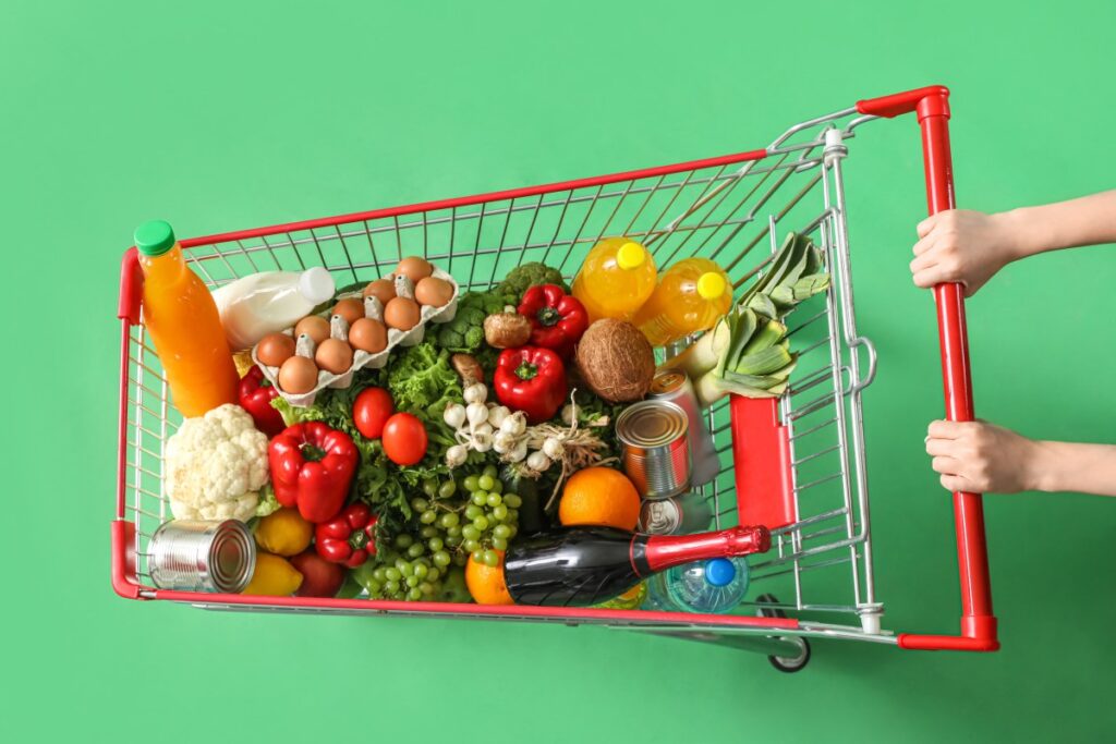 Persona sosteniendo bolsas de compras de Amazon Fresh con productos frescos y sonriendo