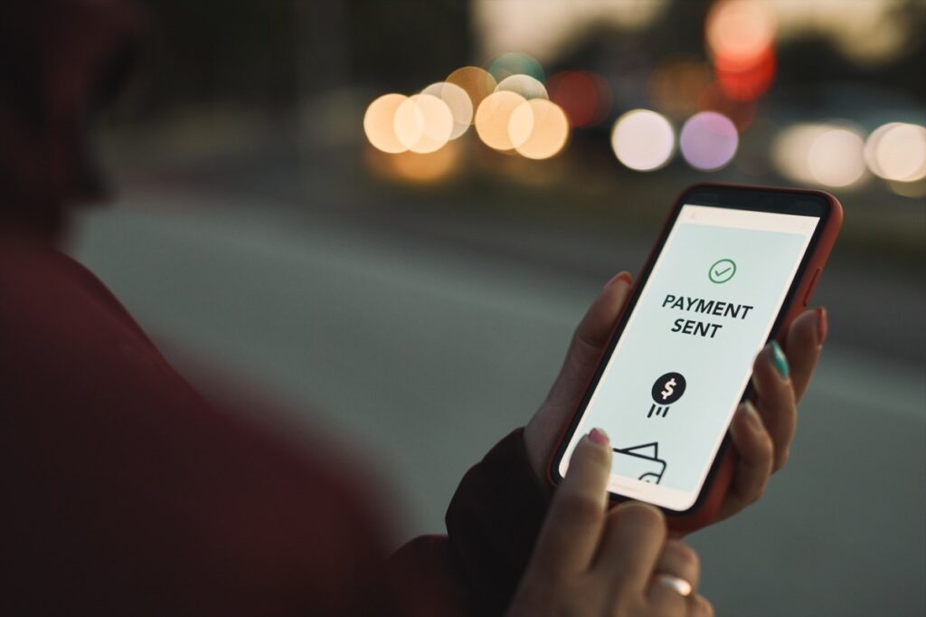 Persona usando app de remesas en smartphone para evitar impuesto del 1%