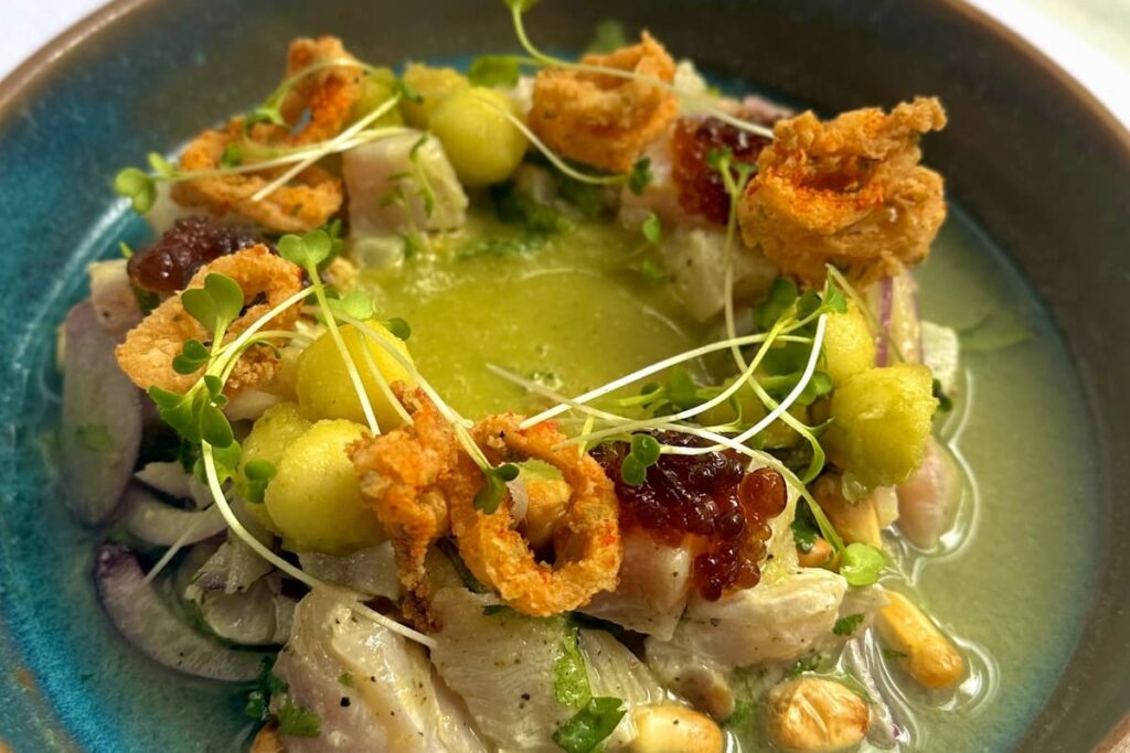 Ceviche clásico peruano con pescado fresco, limón, ají y cebolla morada en plato tradicional