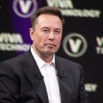 Elon Musk sonriendo mientras mira una pantalla con gráficos financieros que reflejan el crecimiento de su patrimonio