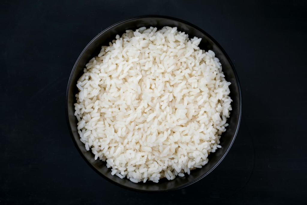 Una deliciosa porción de arroz blanco cocinado con ajo, cebolla y caldo.