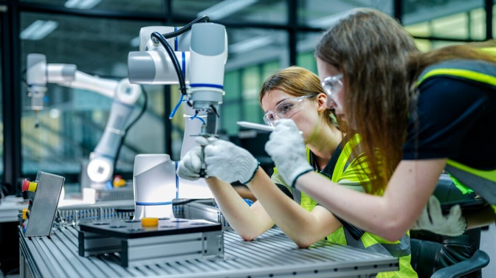 Técnicos trabajando en sala limpia de fábrica de semiconductores con equipos de protección