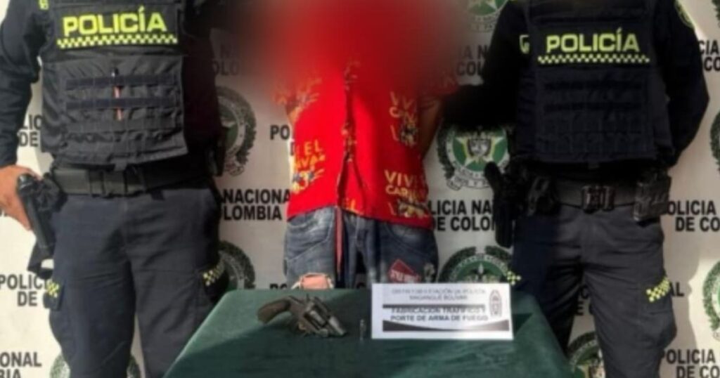 Imagen de un policía capturando a un hombre con un arma de fuego
