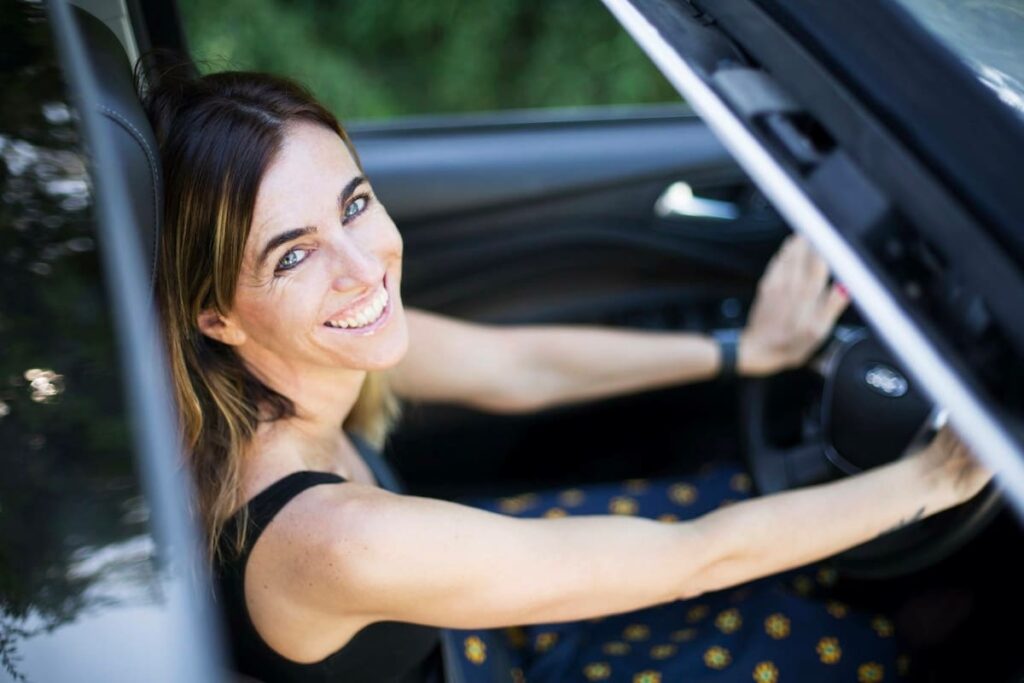 Mujer conduciendo un coche con confianza y seguridad al volante