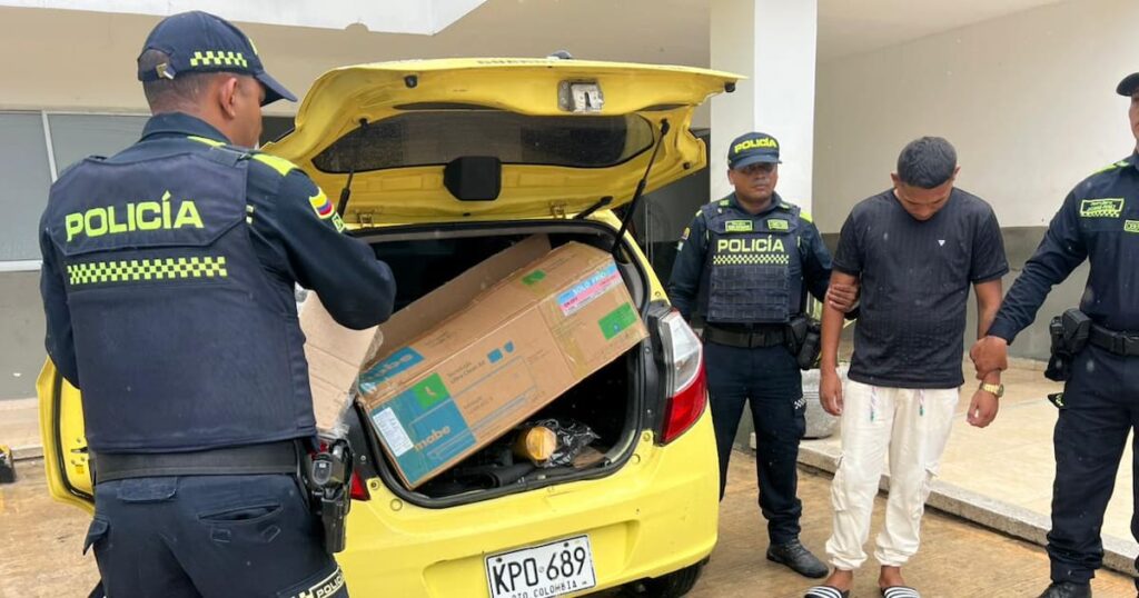 Policías en una carretera con un taxi detenido, incautando paquetes de marihuana