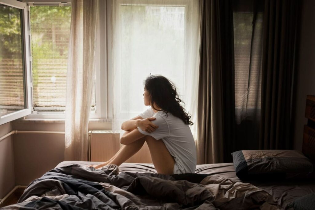 Persona relajada en sofá leyendo un libro en casa con luz natural